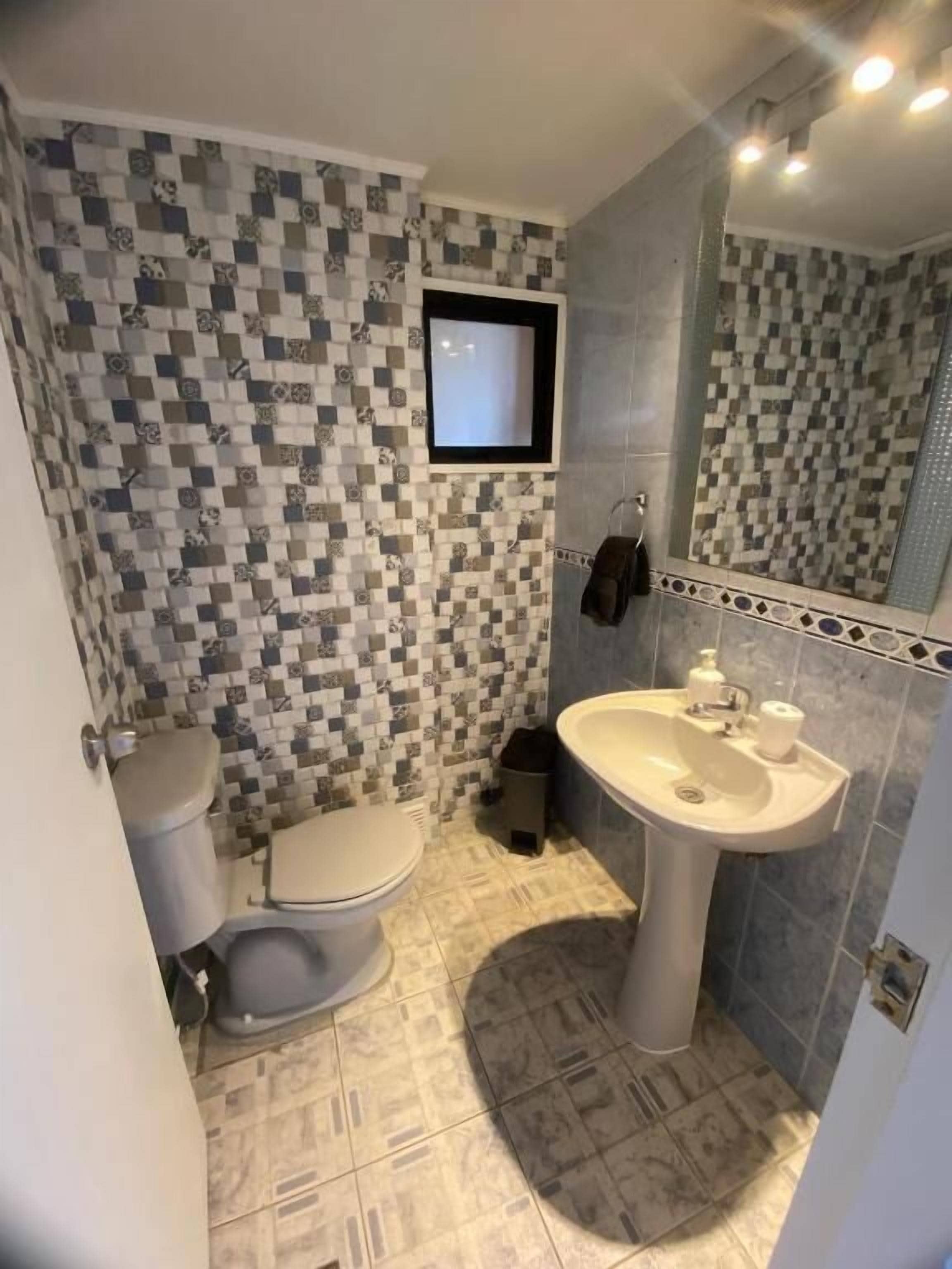 Une salle de bain avec des toilettes, un lavabo et un miroir.