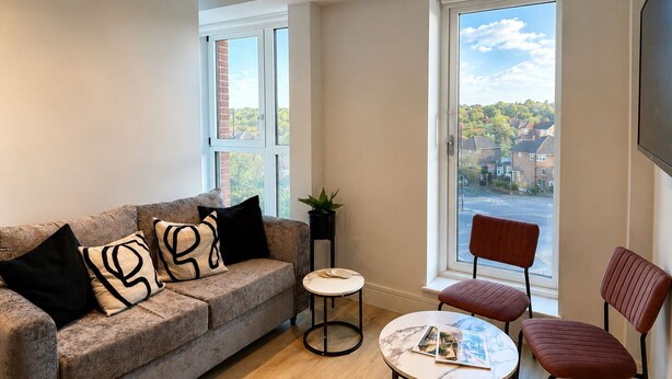 A modern living room with a sofa, a small round table, and two chairs. - Luxury Apartment|Gym, Cinema, work hub & Game Room (London)