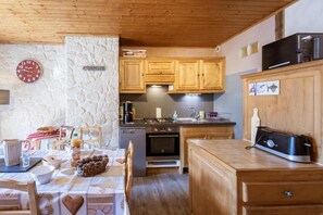 A cozy kitchen with wooden cabinets, a coffee machine, and a toaster. - 300m from ski lifts, 3rd floor, balcony, parking, tv, ski locker, 59m², Valloire (Valloire)