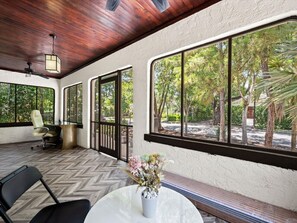 A room with a herringbone floor, a round table with a vase, a chair, and a desk with a chair. - Modern Design District Home 3 King Beds Near Wynwood (Miami)