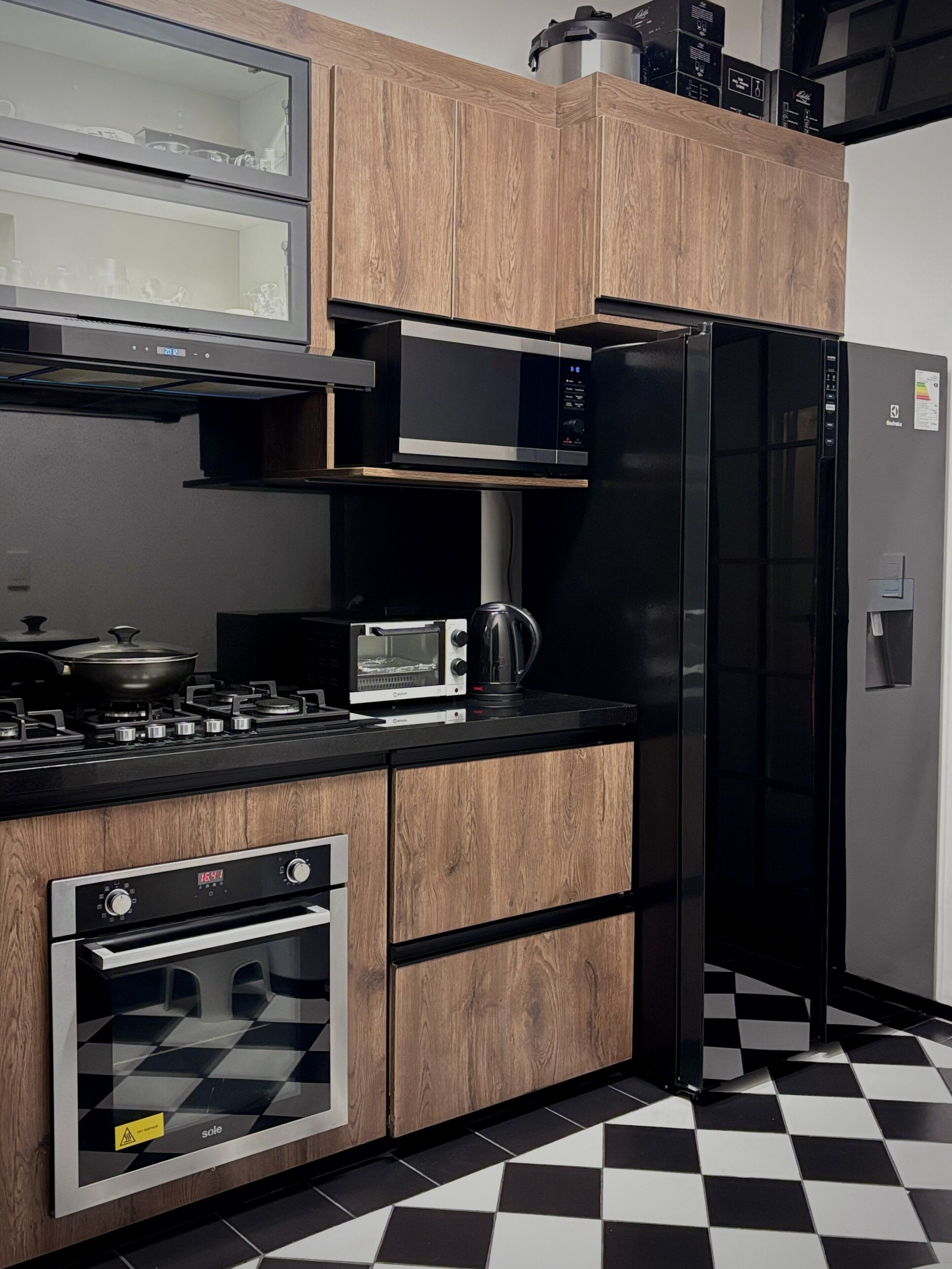 Una cocina moderna con microondas, horno y refrigerador negro.