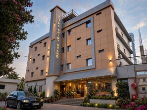 Un hotel de varios pisos con un letrero vertical llamativo que dice 'HOTEL SHINY GRAND'.