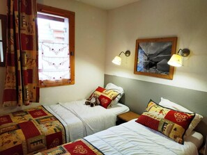 A room with two beds, a window with curtains, wall-mounted lamps, and a painting. - 150m from ski slopes, 1st floor, balcony, tv, ski locker, 36m², Valloire (Valloire)