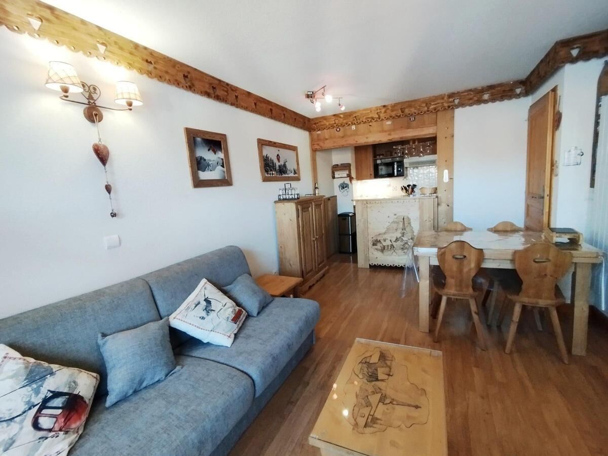Un salon comprenant un canapé, une table à manger en bois, des chaises et une table basse.