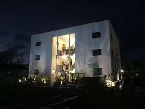 A modern building with a central open staircase leading to an upper floor. - Grace Bay Hideaway. 1 bedroom, central Grace Bay. (Grace Bay)