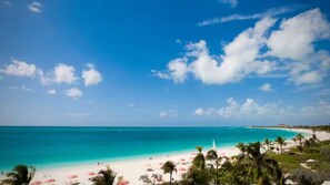 A beach with clear turquoise water, white sand, and palm trees. - Grace Bay Hideaway. 1 bedroom, central Grace Bay. (Grace Bay)