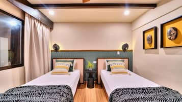 Une chambre d’hôtel avec deux lits, une petite table et un miroir.