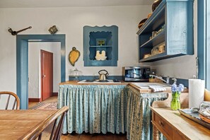 A kitchen with a wooden table, a sink, a stove, and a microwave. - A 1787 home older than the country it stands in (Fredericksburg)