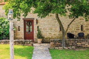 A stone building with a red door, a lantern post, and a small pathway leading to the entrance. - An 1865 limestone barn with gun-slot windows (Fredericksburg)