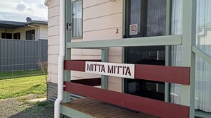Um deck de madeira com uma placa que diz 'MITTA MITTA' e o número '2' acima de uma janela.