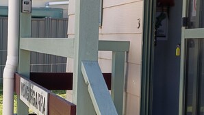 A wooden gate with a sign, a metal door with a keyhole, and a mailbox.