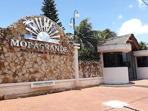 A hotel entrance with a stone wall and a sign that reads 'MORAGRANDE Hotel y Centro de Convenciones.'
