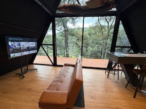 A room with a wooden bench, a table, and a TV screen displaying video content.