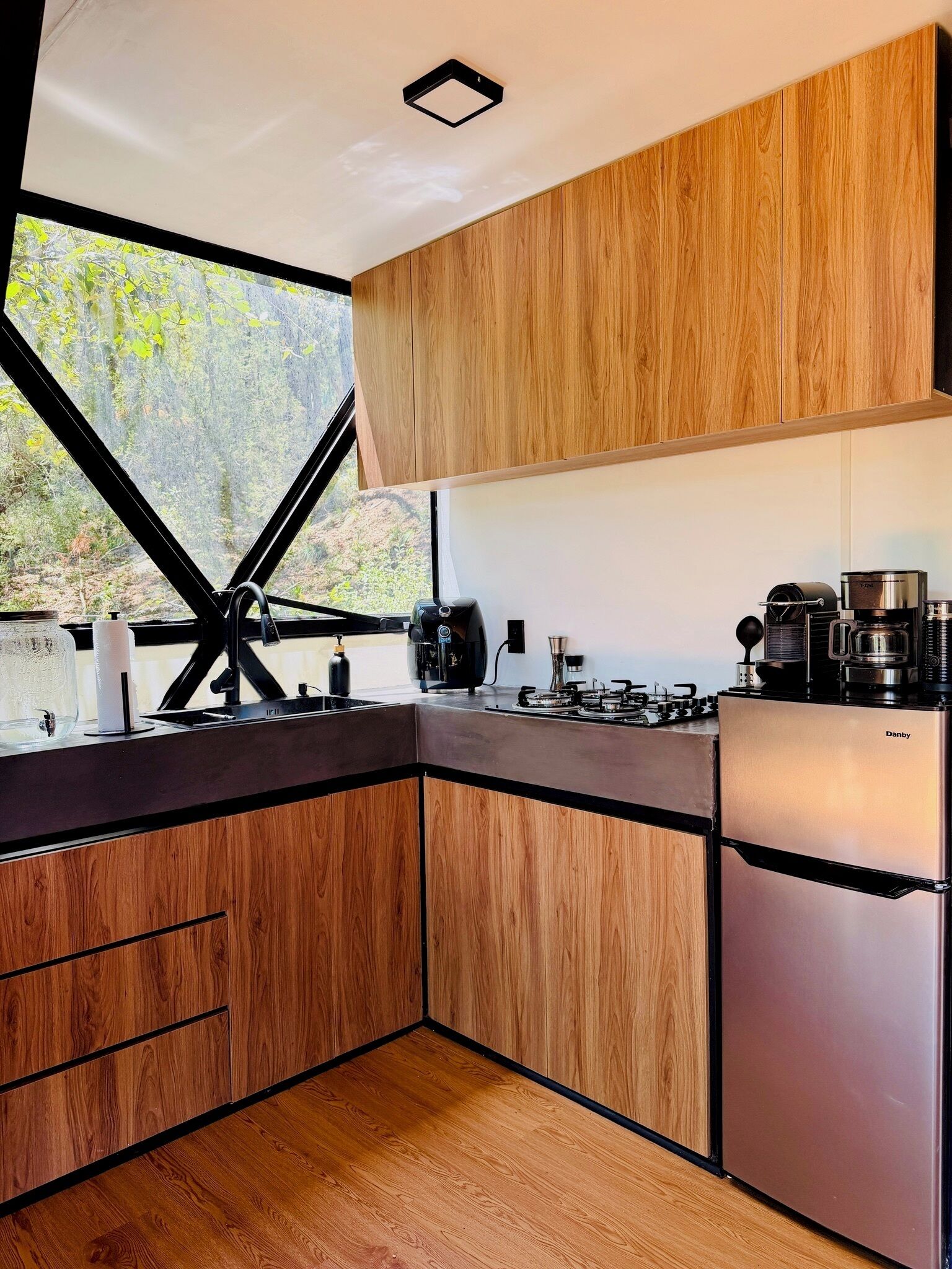 Una cucina moderna con mobili in legno, un frigorifero in acciaio inossidabile e un piano cottura a gas.