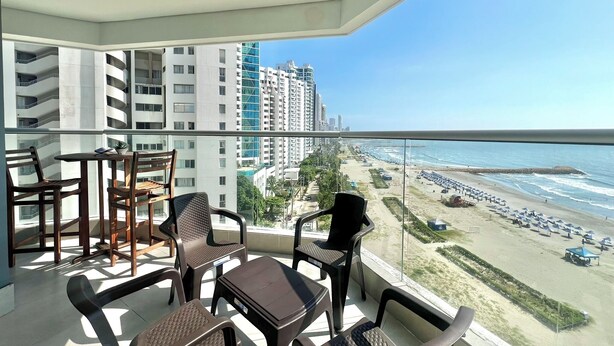 Uma varanda com vista para uma praia e edifícios altos.