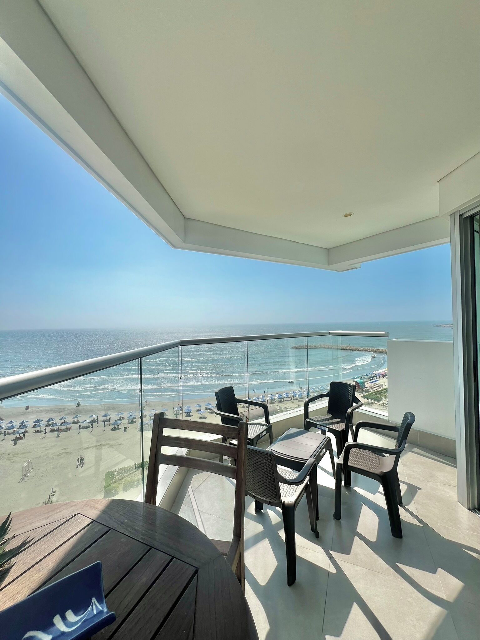 A balcony with a view of the beach and ocean.