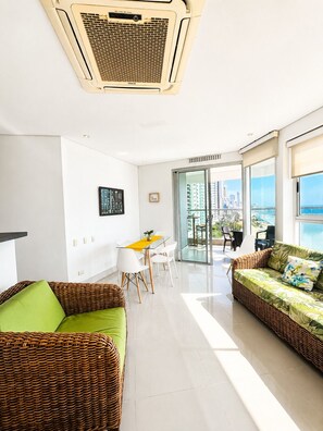 Ein modernes Wohnzimmer mit Essbereich, einem großen Fenster mit Blick auf die Stadt und einer Decken-Klimaanlage.