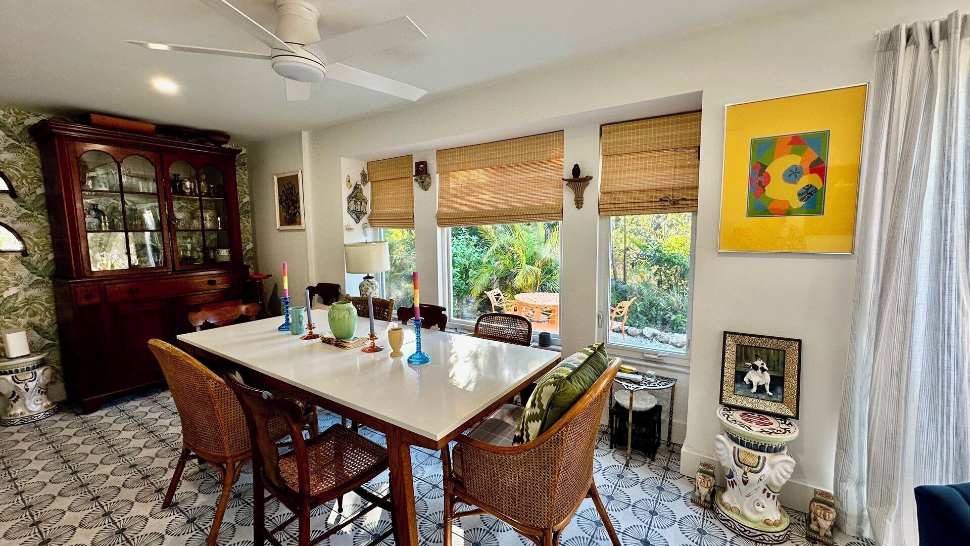 A dining area with a table, chairs, and a ceiling fan.