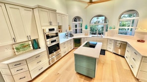 A modern kitchen with white cabinetry, stainless steel appliances, and a central island. - Surf Sound - Luxury 4BR Sanibel Home, Heated Pool, Cabana 5-Min Walk to Beach (Sanibel)