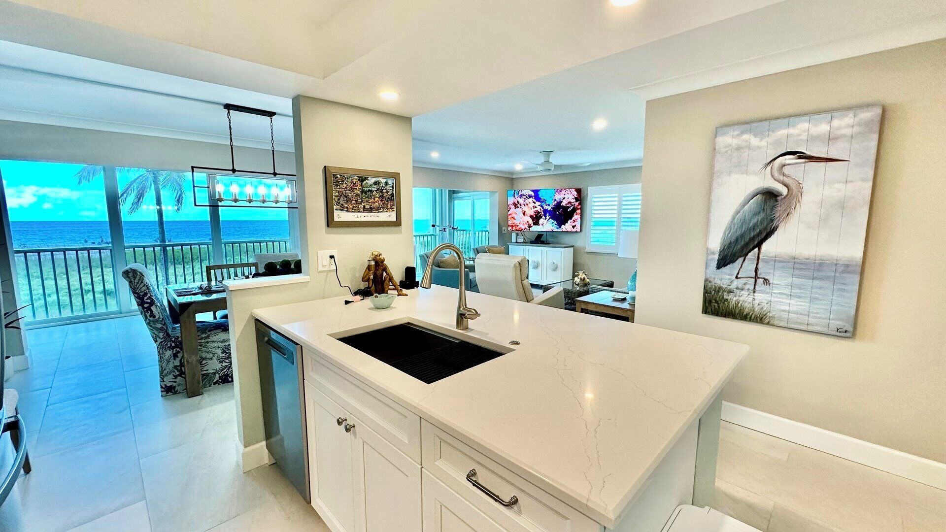 A kitchen with a large island, a view of the ocean, and a dining area with a view.