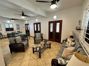 A spacious living area with a dining table, chairs, sofas, and a coffee table.