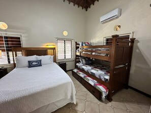 A bedroom with a bunk bed, a single bed, and a nightstand.