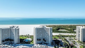 A high-rise hotel with a beachfront view, featuring multiple balconies and a pool area. - Remodeled Beachfront Corner Condo | Marco Island | Sleeps 6 (Marco Island)