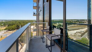 Un balcon offrant une vue sur le paysage urbain, avec ses bâtiments et sa verdure.