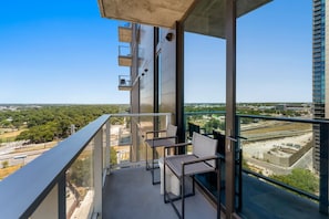 A balcony with a view of a cityscape, including buildings and greenery. - Luxury Downtown Stay l Rooftop Pool & Skyline Views (Austin)