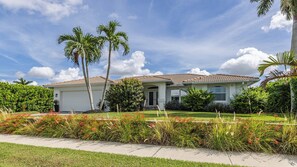 A single-story house with a tiled roof, a front porch, and a well-maintained lawn with flowering plants. - Waterleaf Ct, 363 in Marco Island, FL (Marco Island)