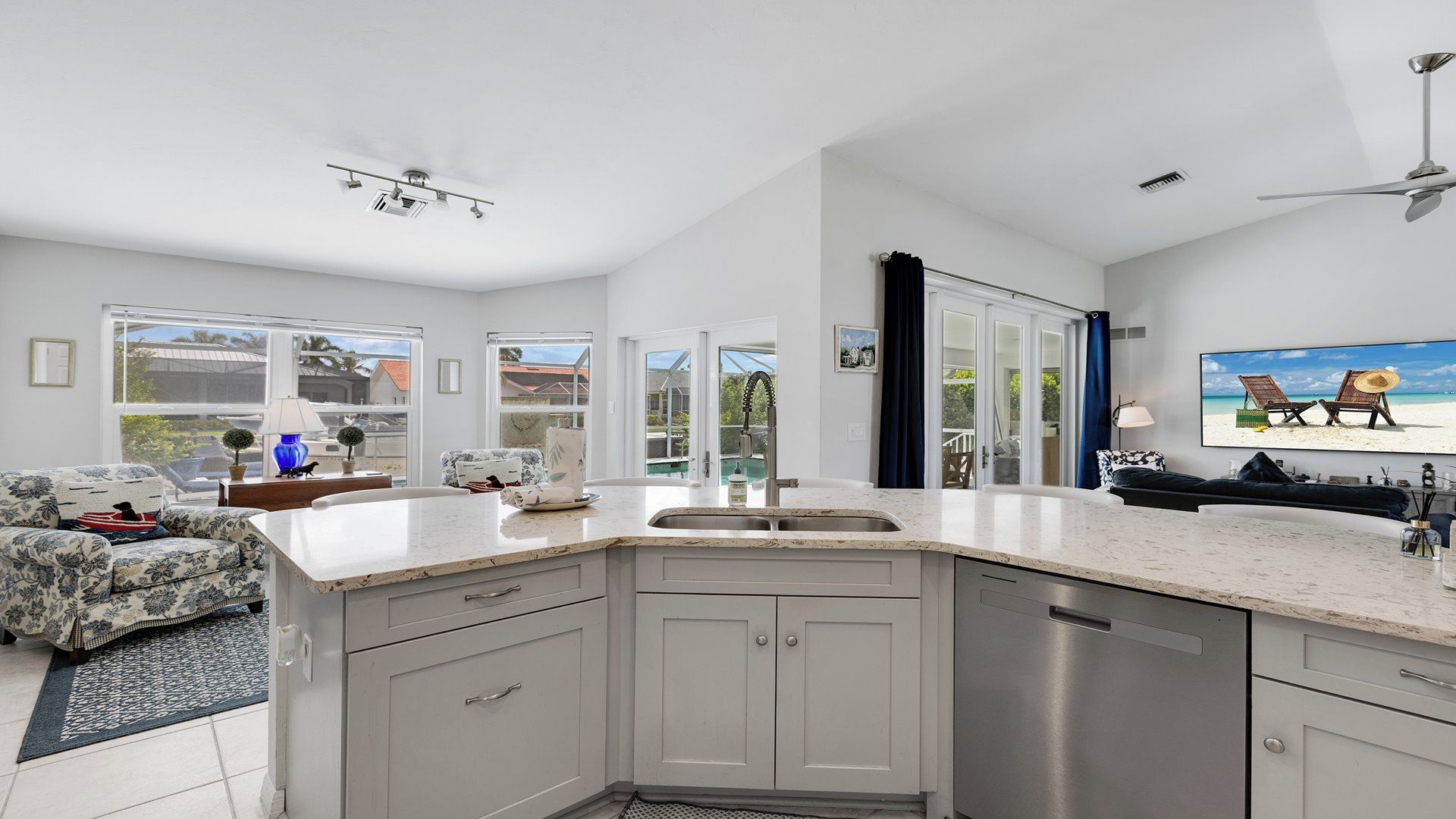 A modern kitchen with a large island, built-in appliances, and a view to the outdoor area.