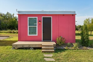 Un petit bâtiment d’un seul étage, à l’extérieur rouge, avec une porte d’entrée et une boîte aux lettres.