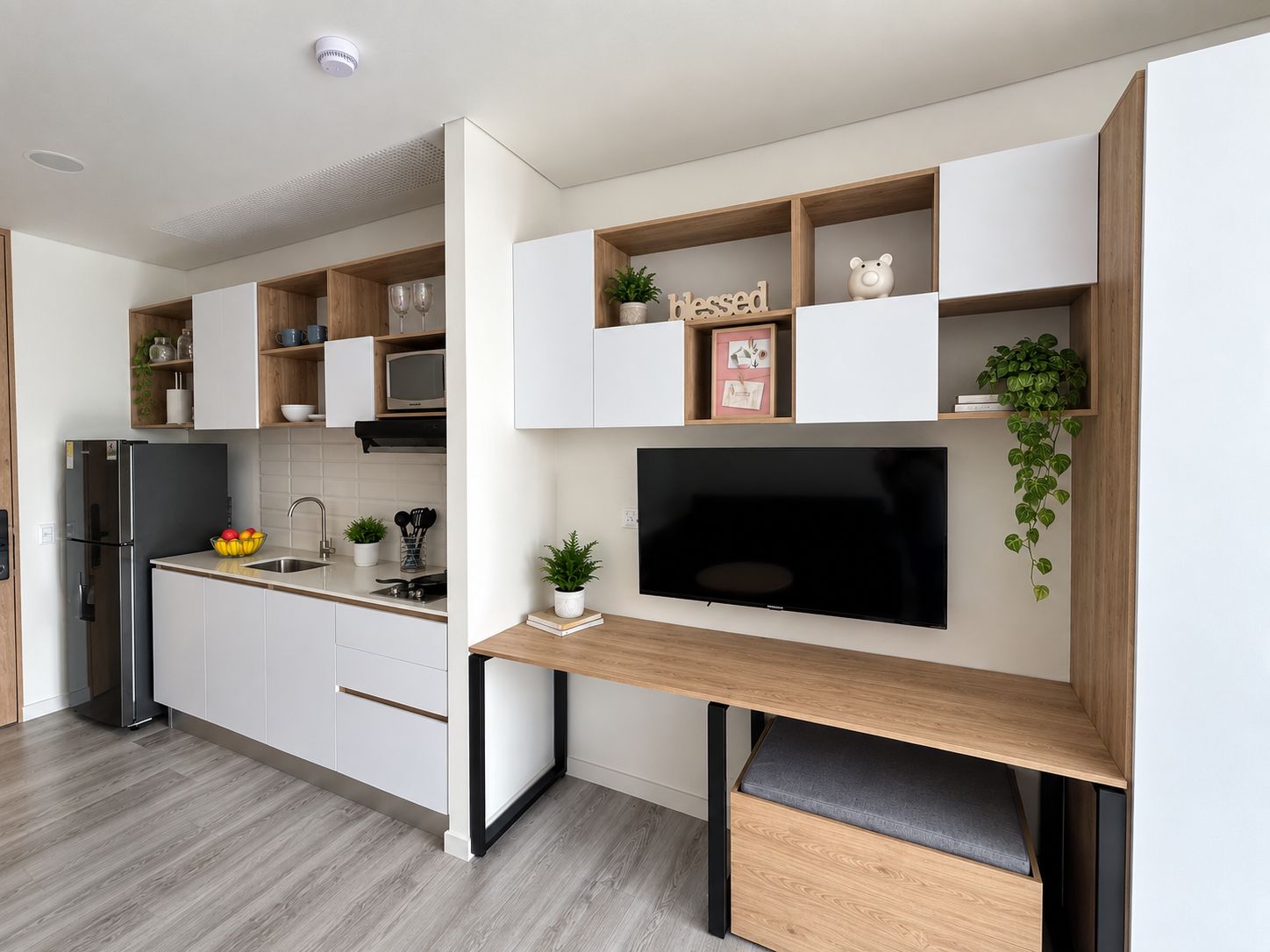 Una cocina moderna con electrodomésticos integrados, un televisor de pantalla plana y una zona de comedor con banco.