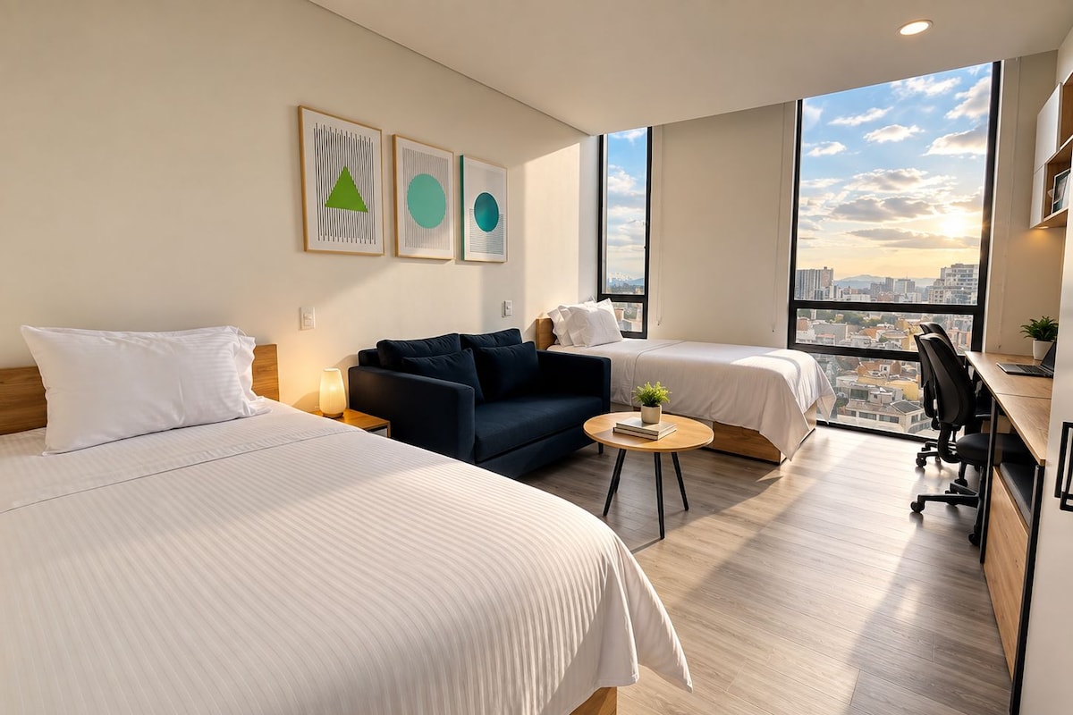 Quarto de hotel com duas camas, um sofá, uma escrivaninha e vista para a cidade.