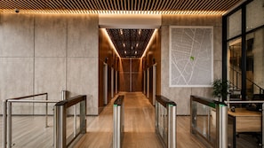 A modern hallway with a wooden ceiling, a map on the wall, and a staircase to the right. - Esstadia33DC (Bogotá)