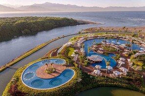A resort with a large central pool, multiple smaller pools, and a beach area. - Grand Luxxe Villa with VIP resort amenities (Las Jarretaderas)