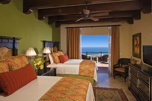 A hotel room with two beds, a television, a balcony with a view of the ocean, and a ceiling fan. - Beautiful Oceanview Villa at Pueblo Bonito (Cabo San Lucas)