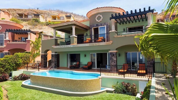 Uma casa de vários andares com piscina, varandas e áreas de estar ao ar livre.