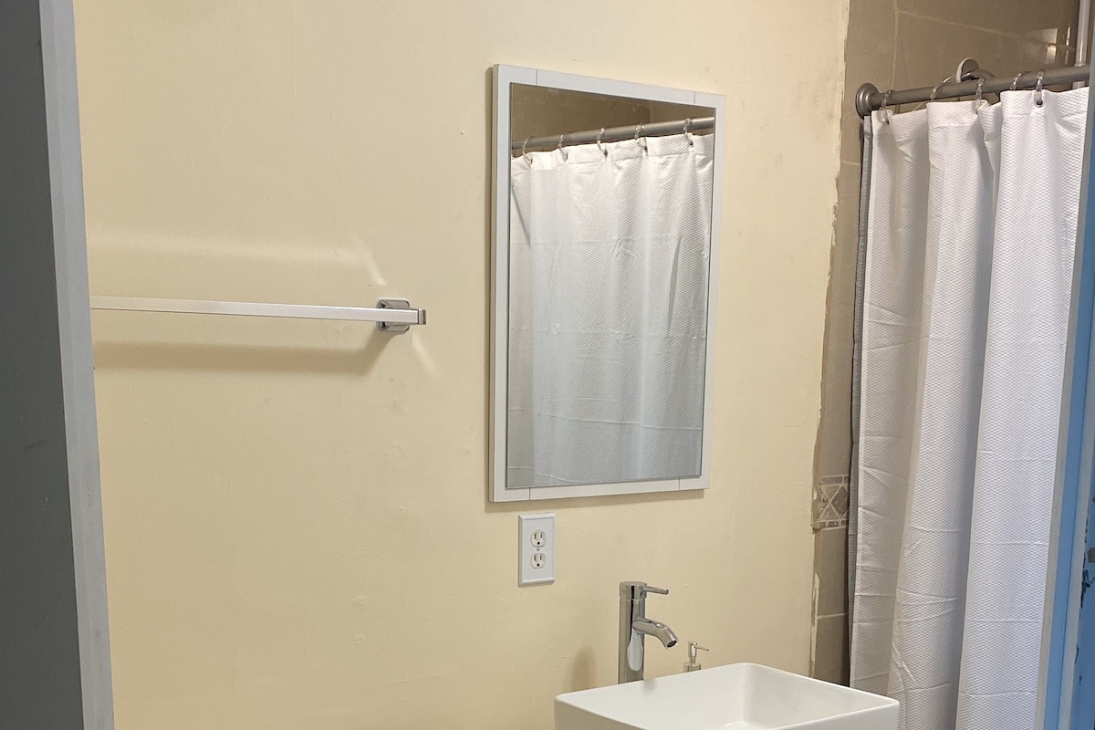 A bathroom with a toilet, sink, and shower curtain.
