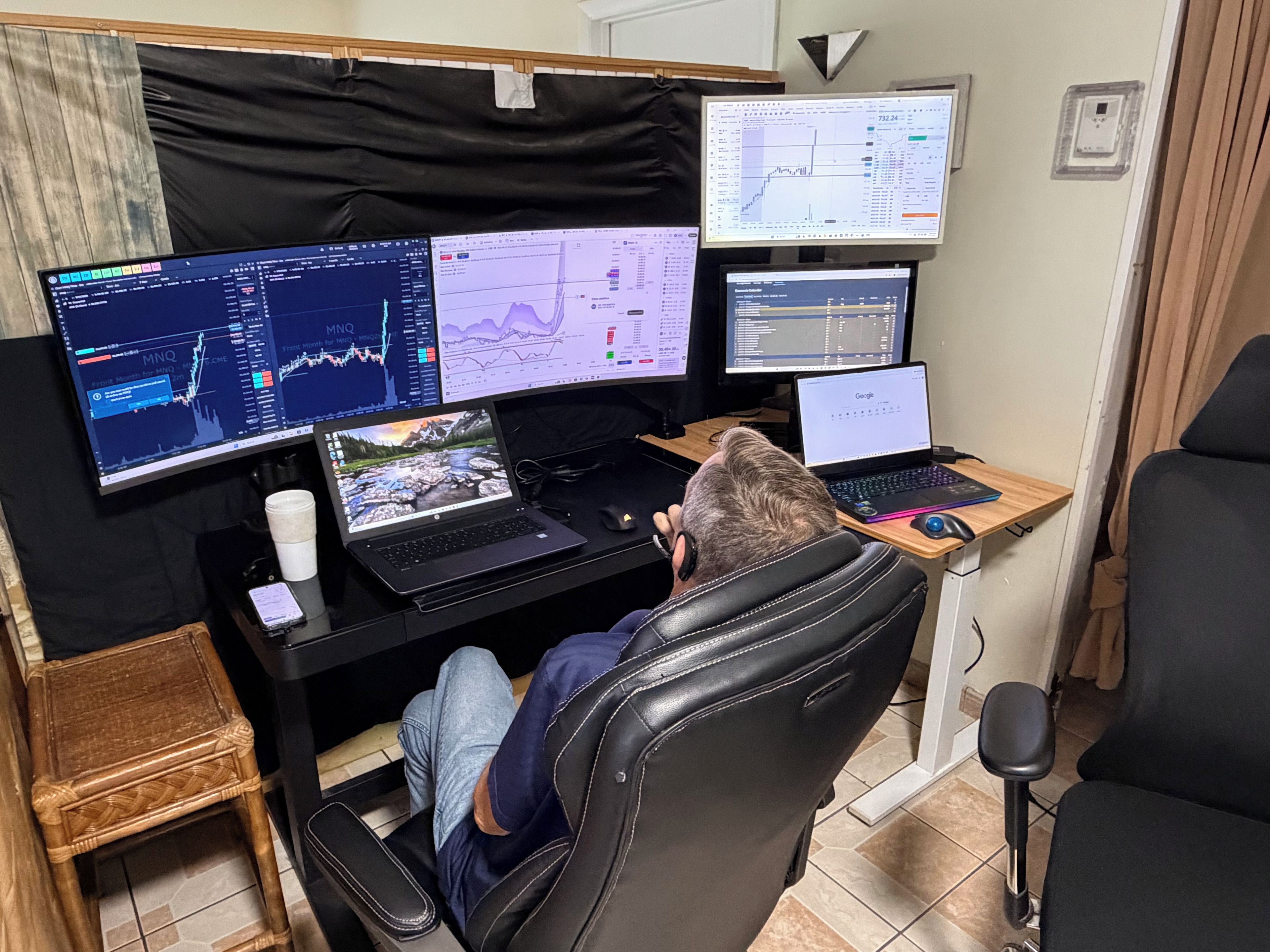 Un espacio de trabajo con varios monitores, una computadora portátil y un teléfono inteligente sobre un escritorio.
