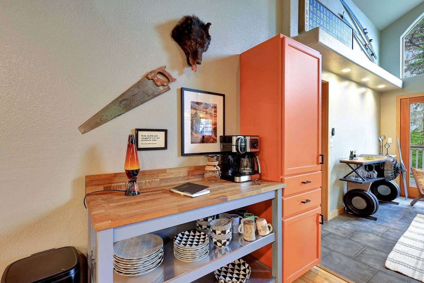 A kitchen with a coffee machine, a framed picture, and a rustic decor piece.