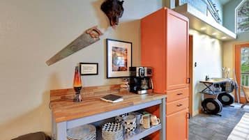 A kitchen with a coffee machine, a framed picture, and a rustic decor piece.