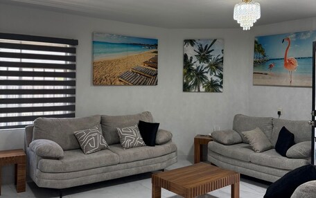 A living room with two sofas, a coffee table, and artwork on the walls.