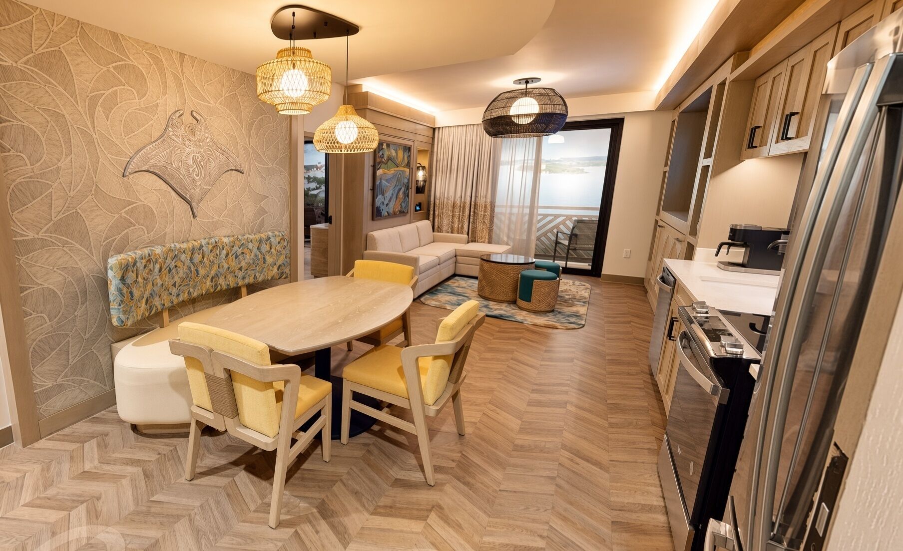 A modern kitchen with a dining area, wooden herringbone flooring, and a view to the outside.
