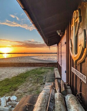 A building with a sign reading 'LES PIRELONS' and a view of the sunset over a beach. - Ferdinand's Cabin • Beach: 2 min • Private patio • Air Conditioning • Fiber (Arcachon)