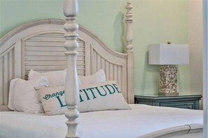 A bed with a white headboard and two pillows, one with the word 'ATTITUDE' and another with the word 'CHANGE'. - Margaritaville 4BR | Sleeps 10 | Near Disney (Kissimmee)