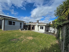 A residential property with a fenced backyard, a small patio area, and a satellite dish. - Middleton Near The Beach (Paraparaumu Beach)