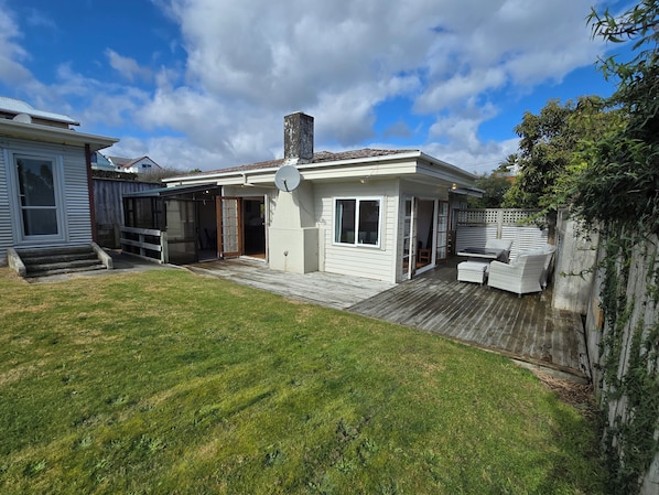 A residential property with a covered patio, a satellite dish, and a fenced yard.