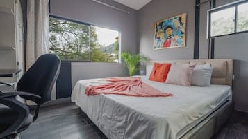 Un dormitorio moderno con una cama, una silla, una ventana y un cuadro.