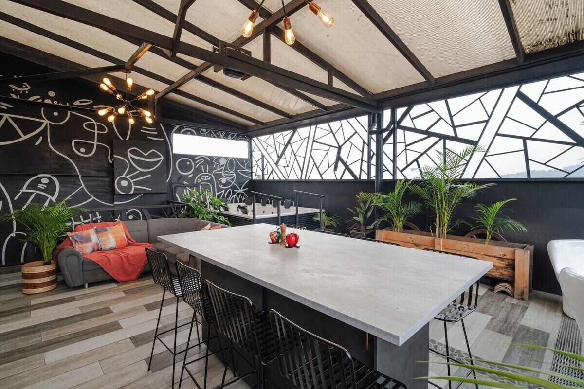 Un interior moderno con una zona de bar central, asientos y un diseño de pared geométrico.